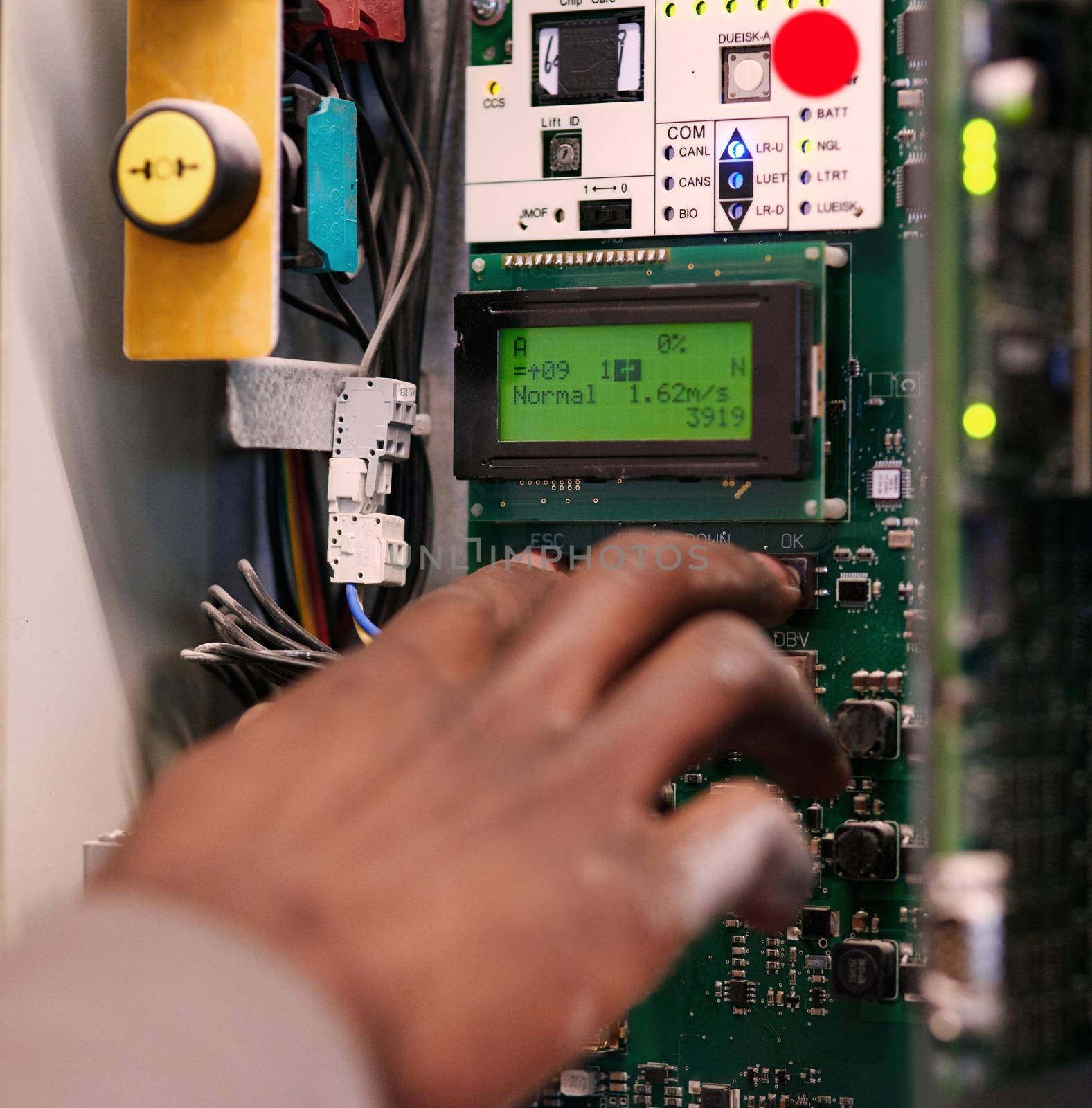 Cropped shot of an unidentifiable man pressing a button on an electrical panel.