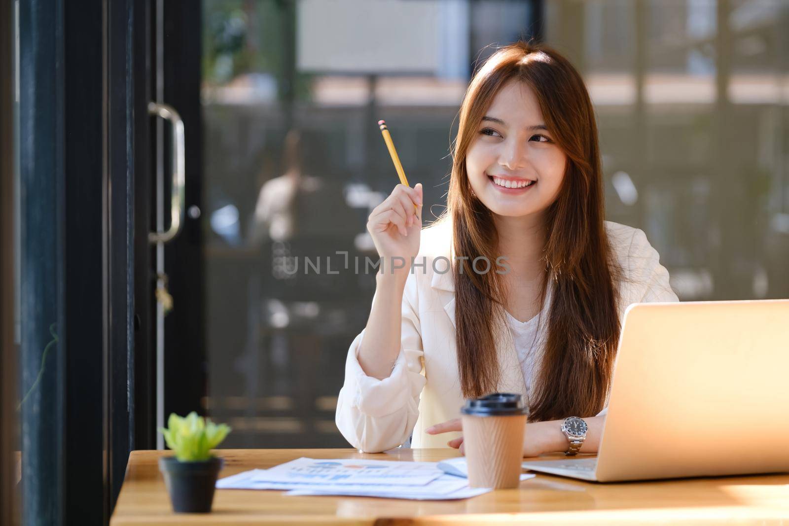 Happy businesswoman relaxing at office desk.