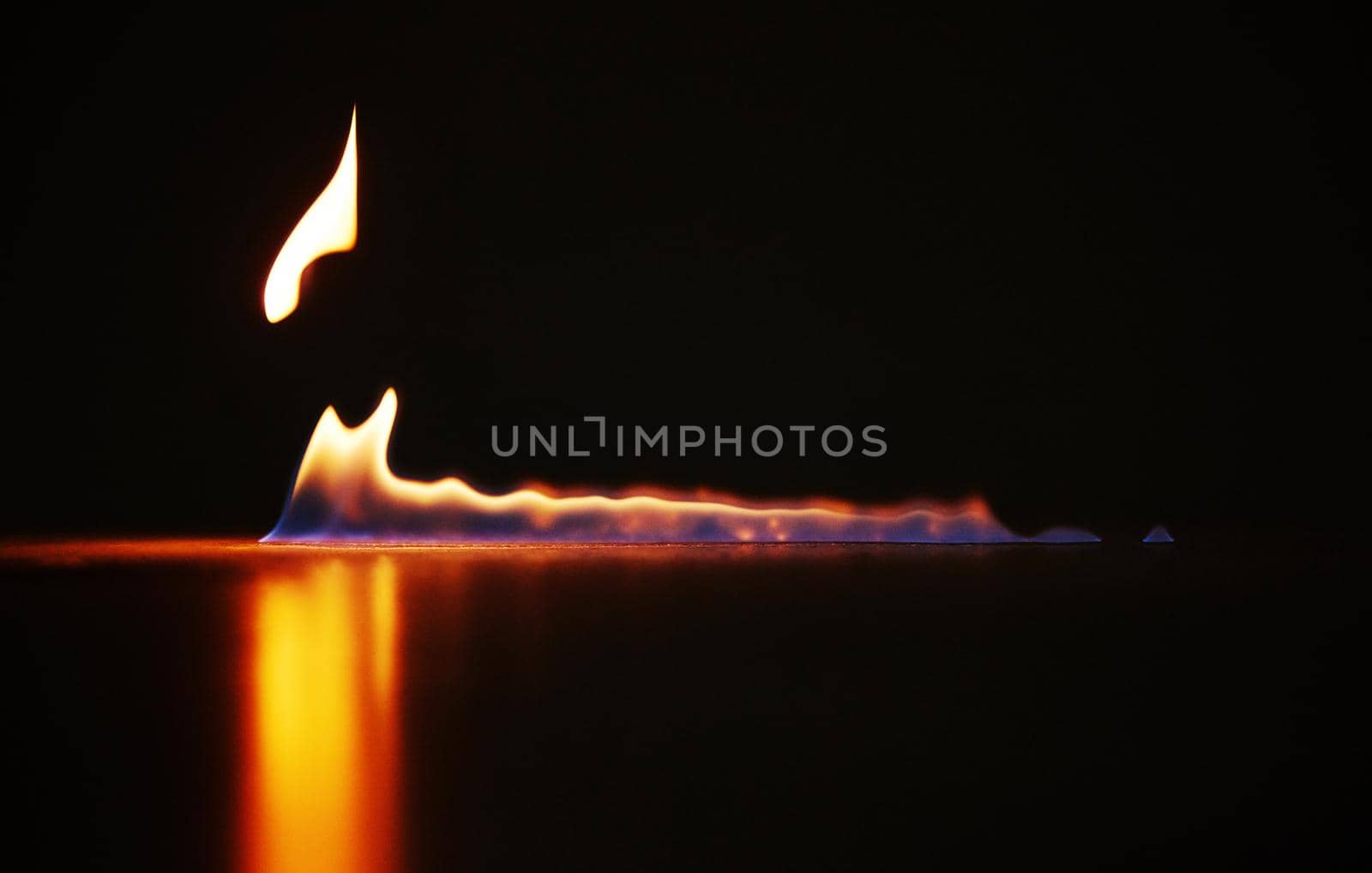 What is beautiful can often destroy. Studio shot of a small flame burning against a black background. by YuriArcurs