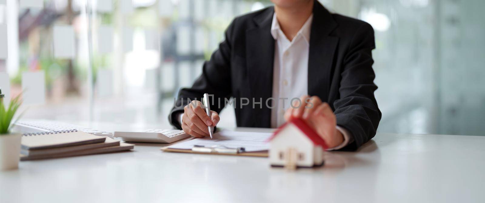 Business woman working doing finances and calculation cost of real estate investment while be signing to contract, Concept mortgage loan approval