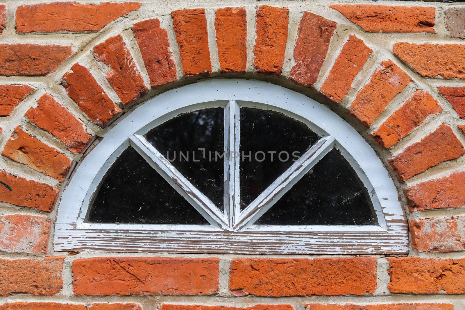 Old brick wall. Texture of old weathered brick wall with a round window