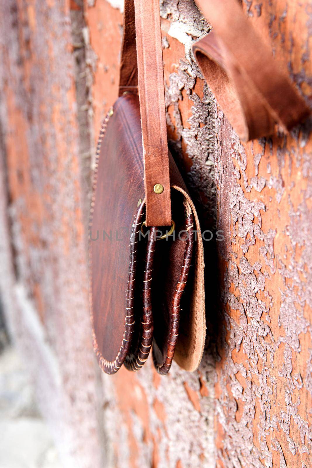 small brown women's leather bag with a carved pattern. selective focus by Ashtray25