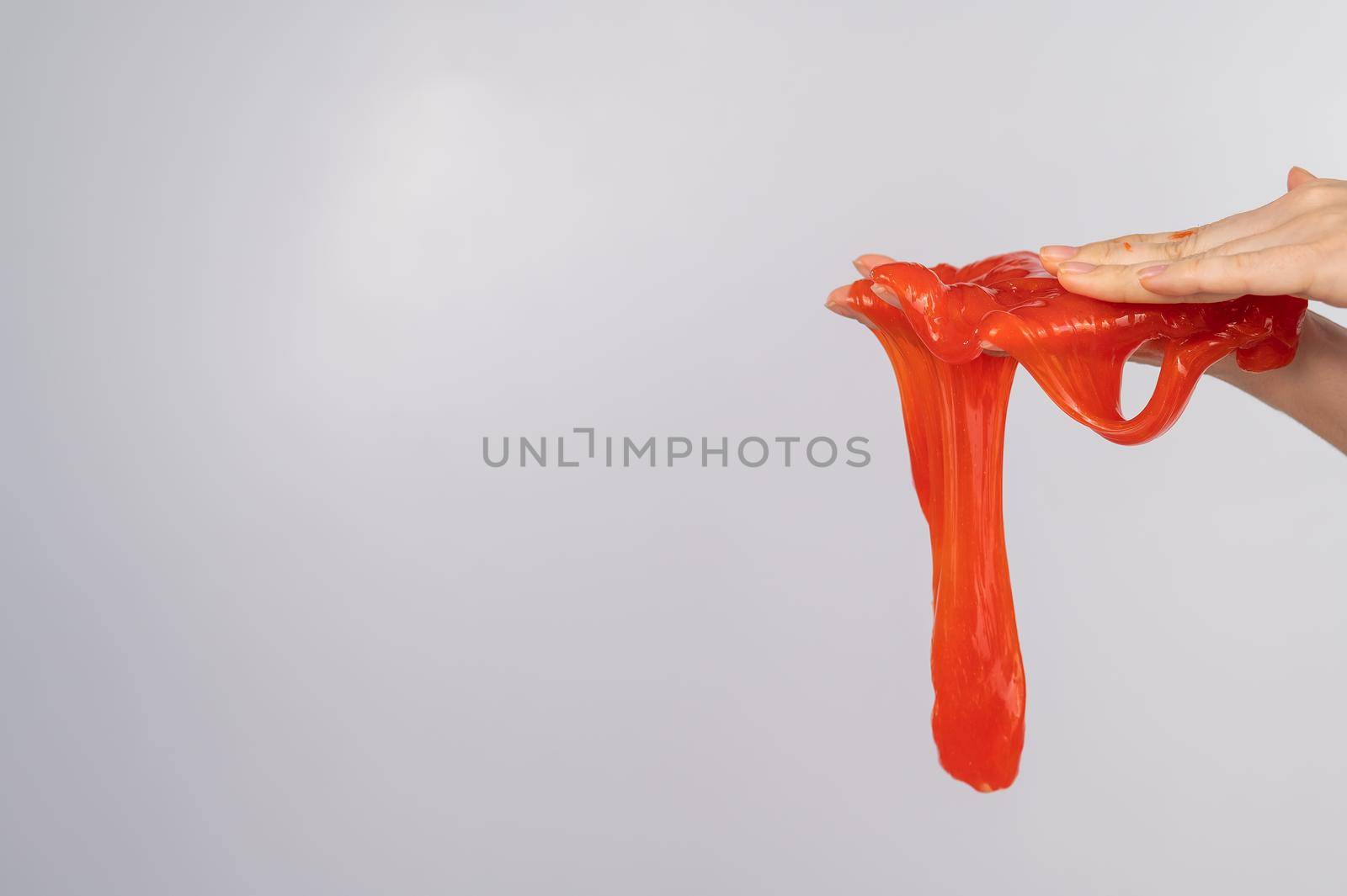 Red slime flowing down from a woman's hand on a white background