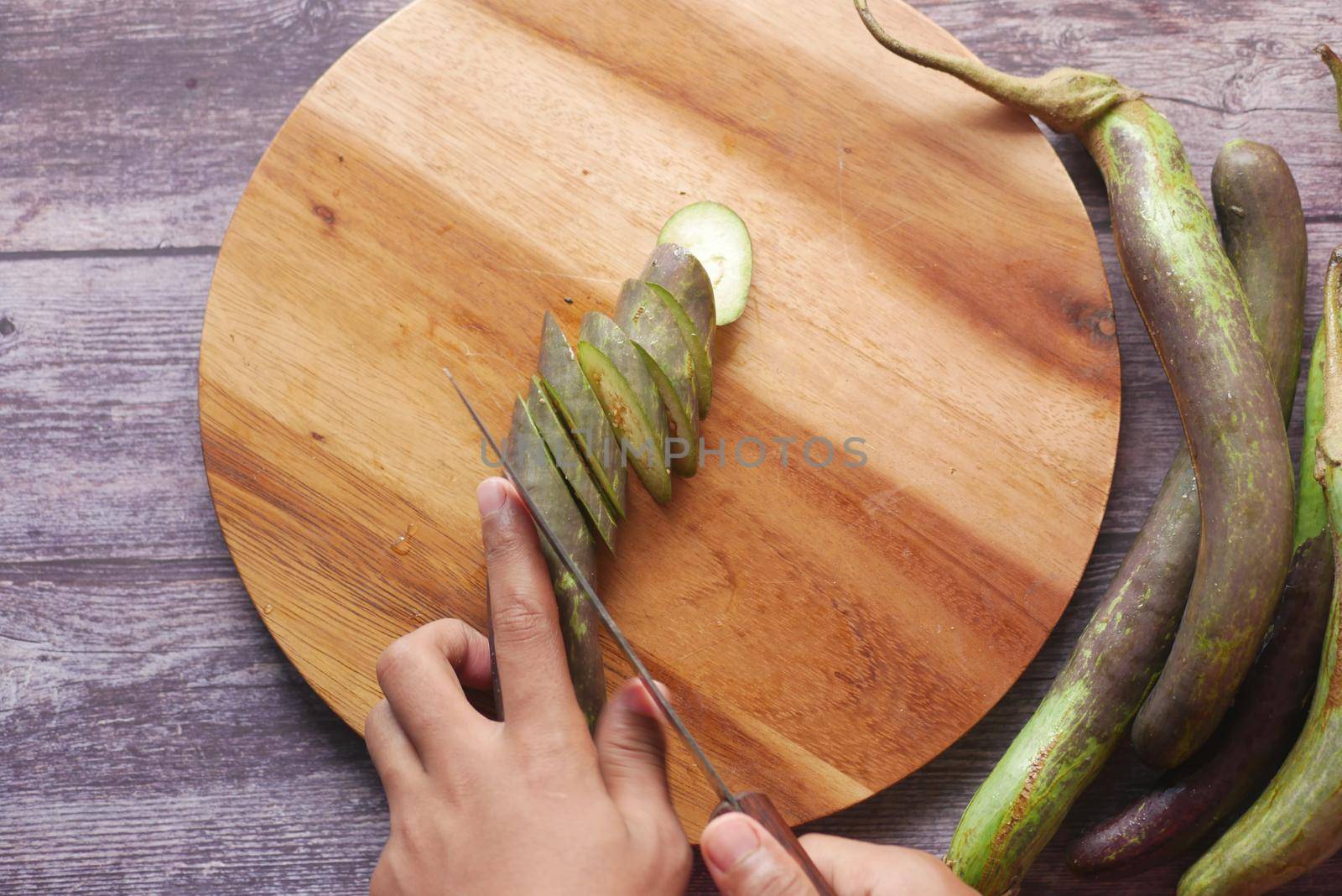cutting eggplant on a chopping board .