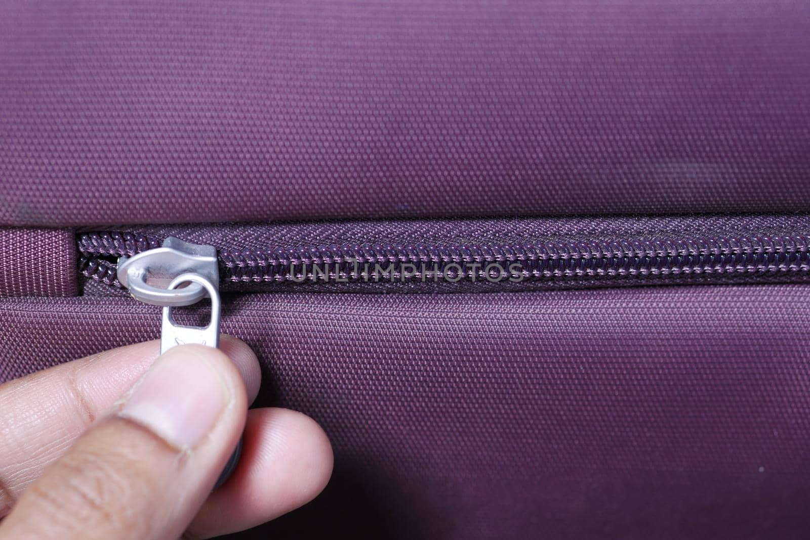 hand in a Zipper on a suitcase close up