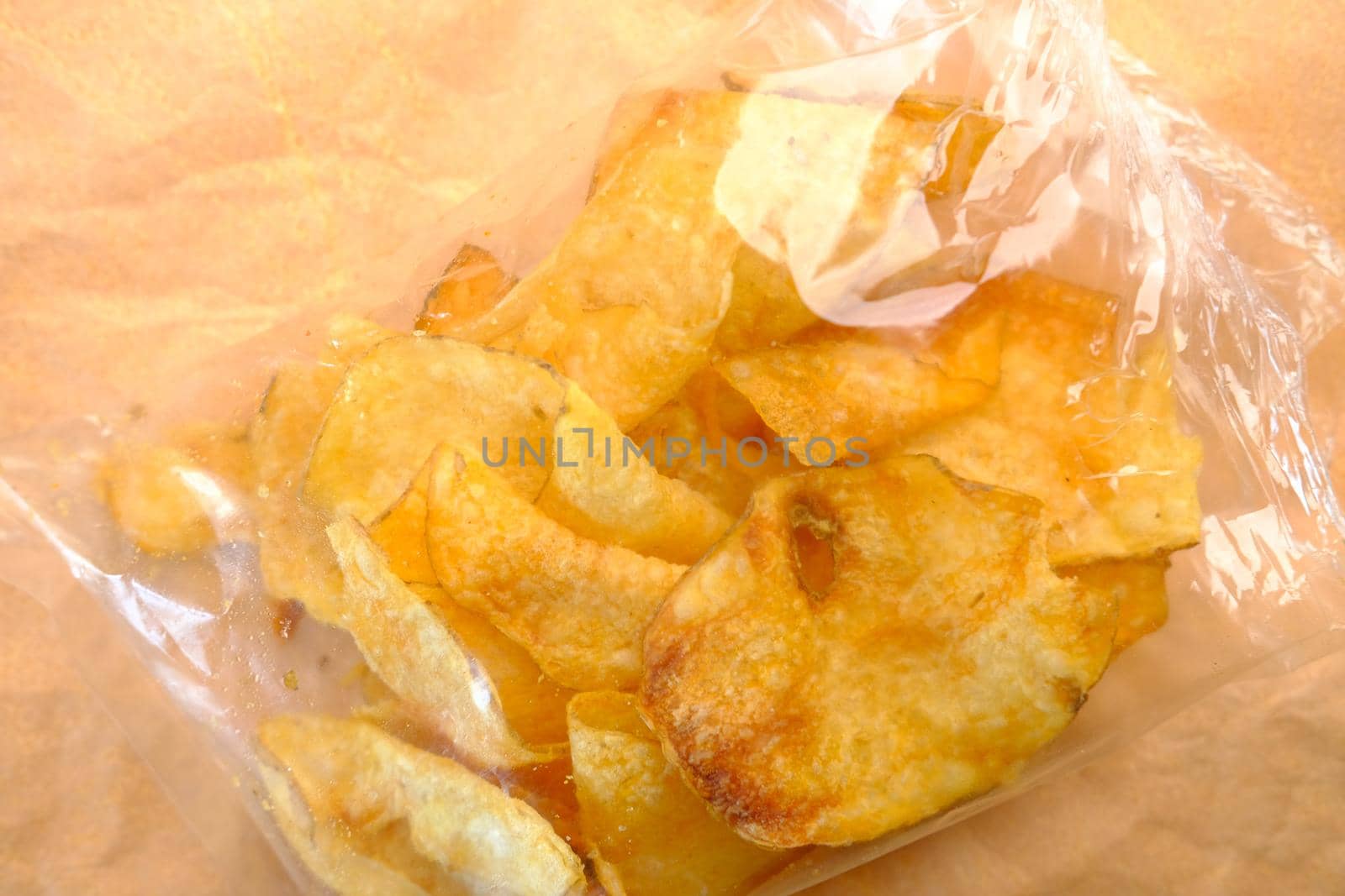tasty potato chips in a packet top down .