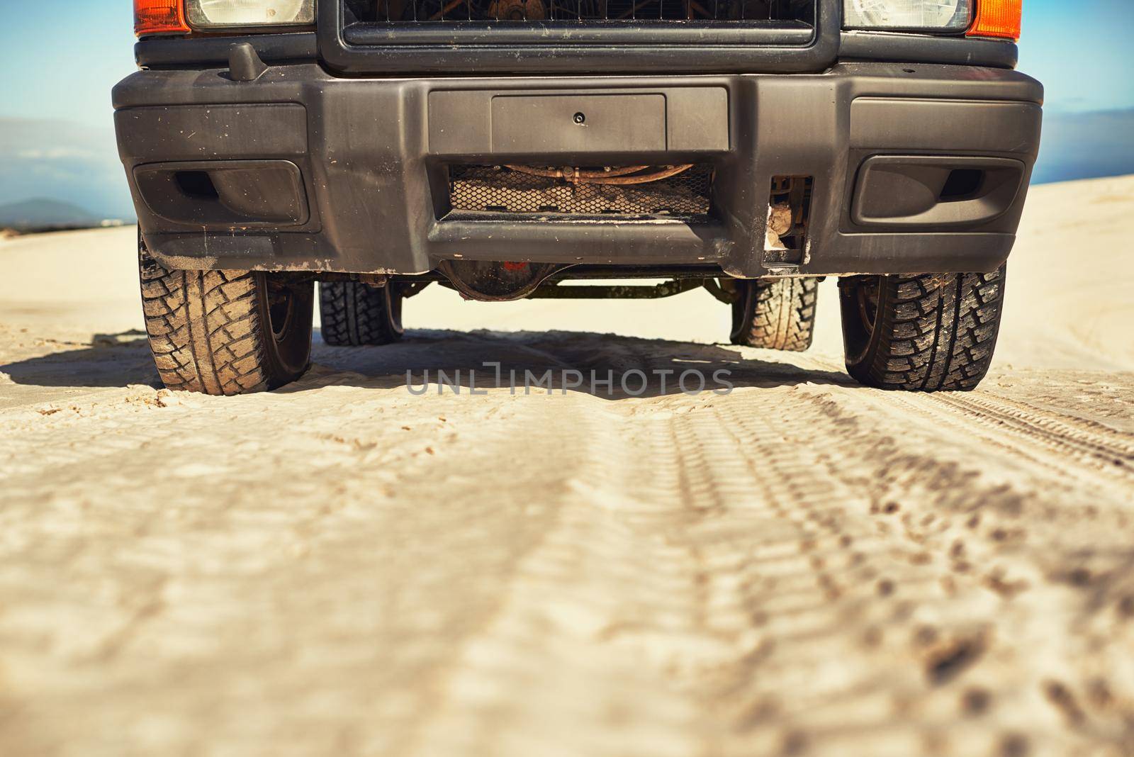 Making tracks through the desert. Shot of a heavy duty 4x4 driving along some sand dunes. by YuriArcurs