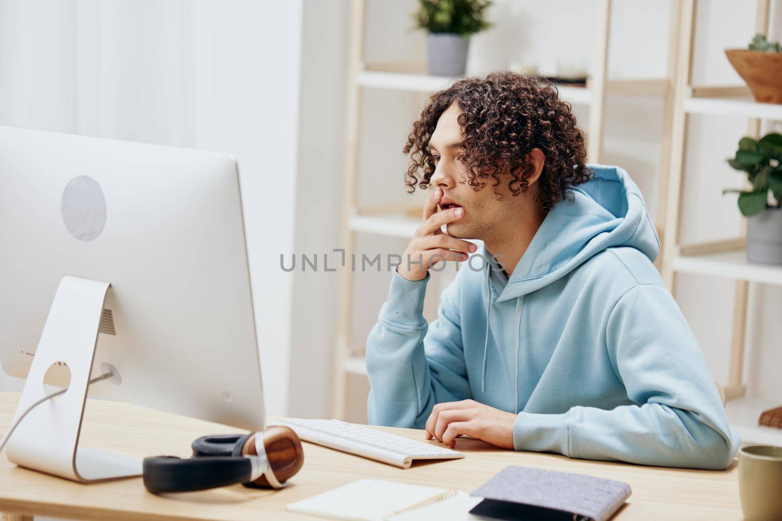 portrait of a man in a blue jacket in front of a computer with phone Lifestyle. High quality photo