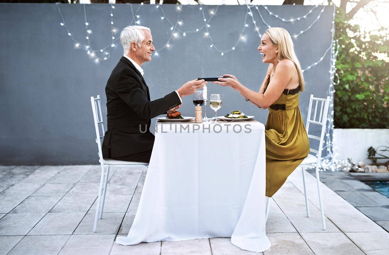 She loves it when I surprise her with unexpected gifts. Shot of a mature couple out on a romantic date. by YuriArcurs