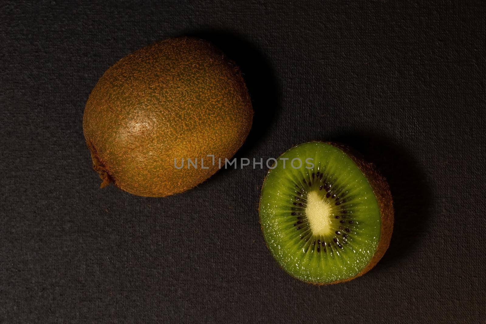 Kiwi fruits on black background. Top view with copy space, flat lay. by clusterx