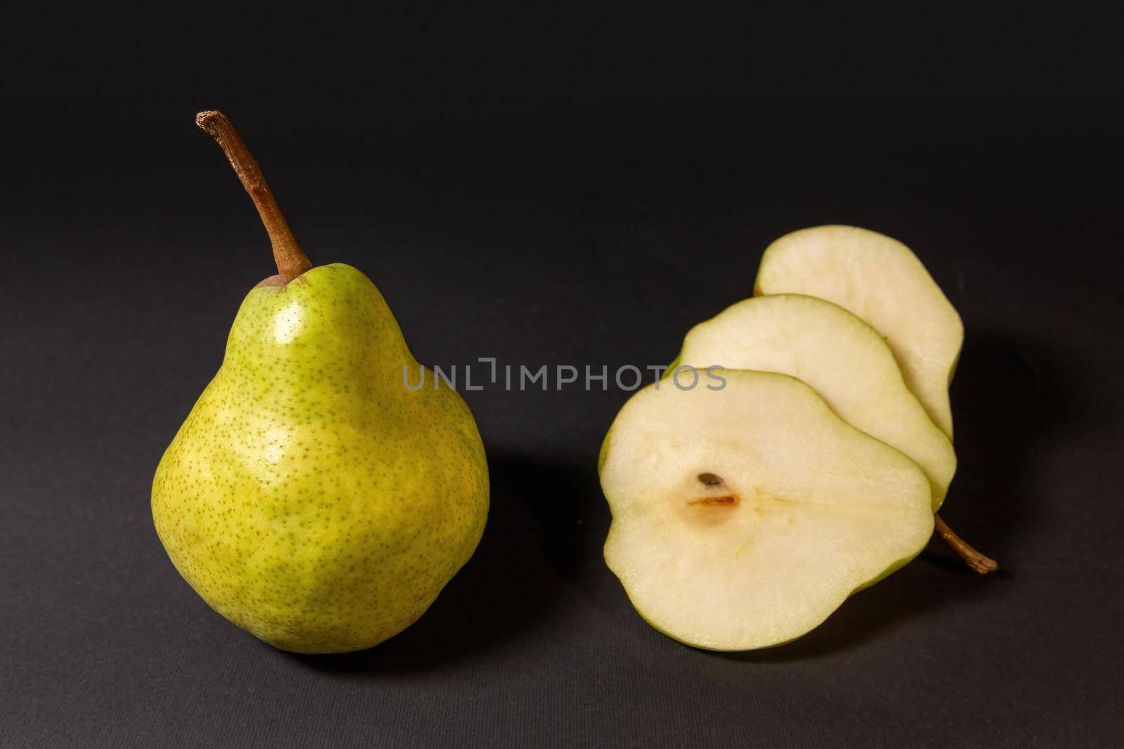 Ripe green pear on a dark background by clusterx