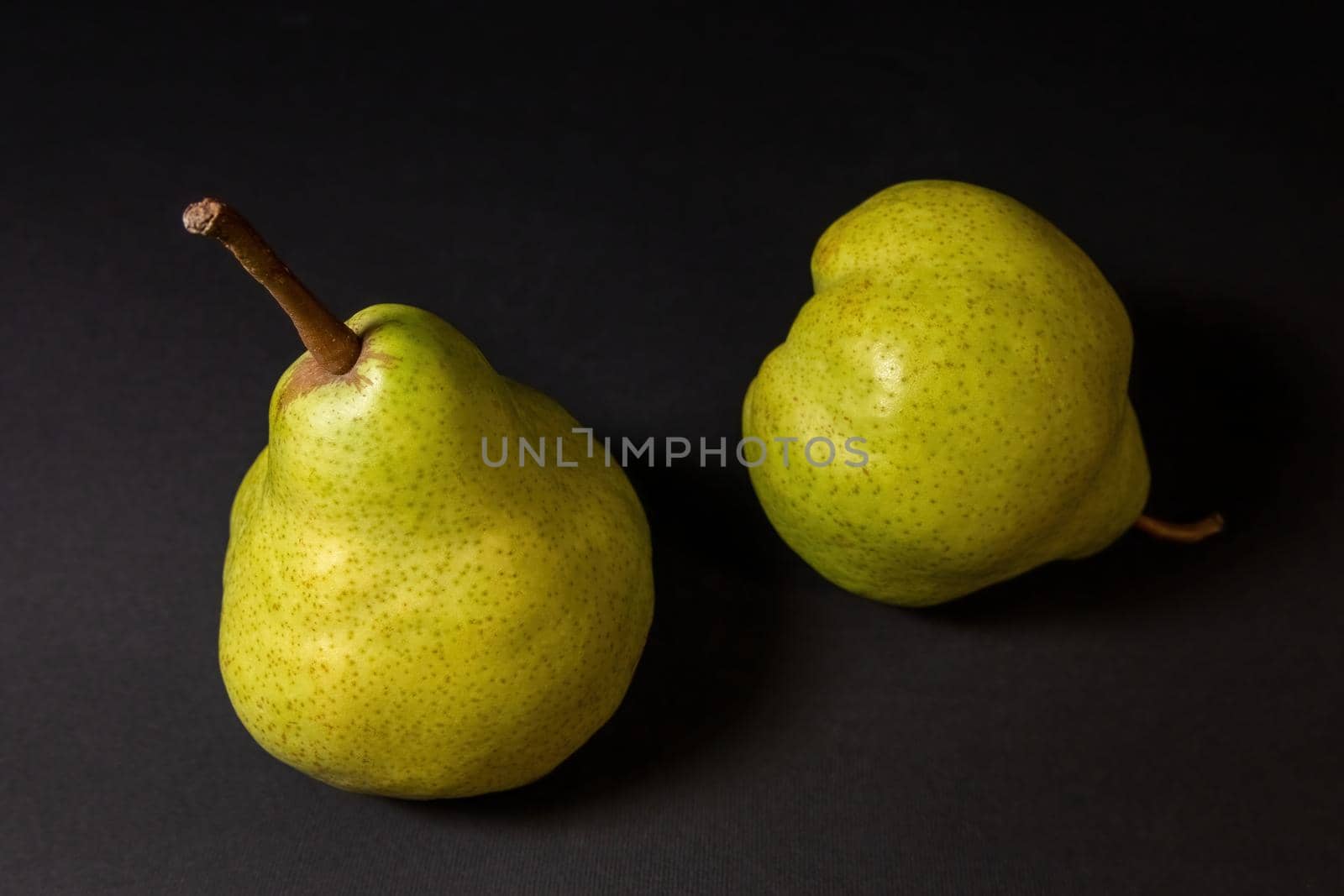 Ripe green pear on a dark background by clusterx