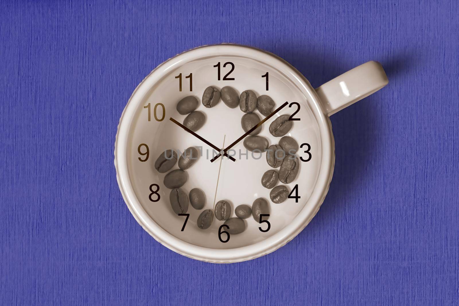 Coffee cup with coffee beans inside and a clock on top of the cup on blue background. Coffee time concept