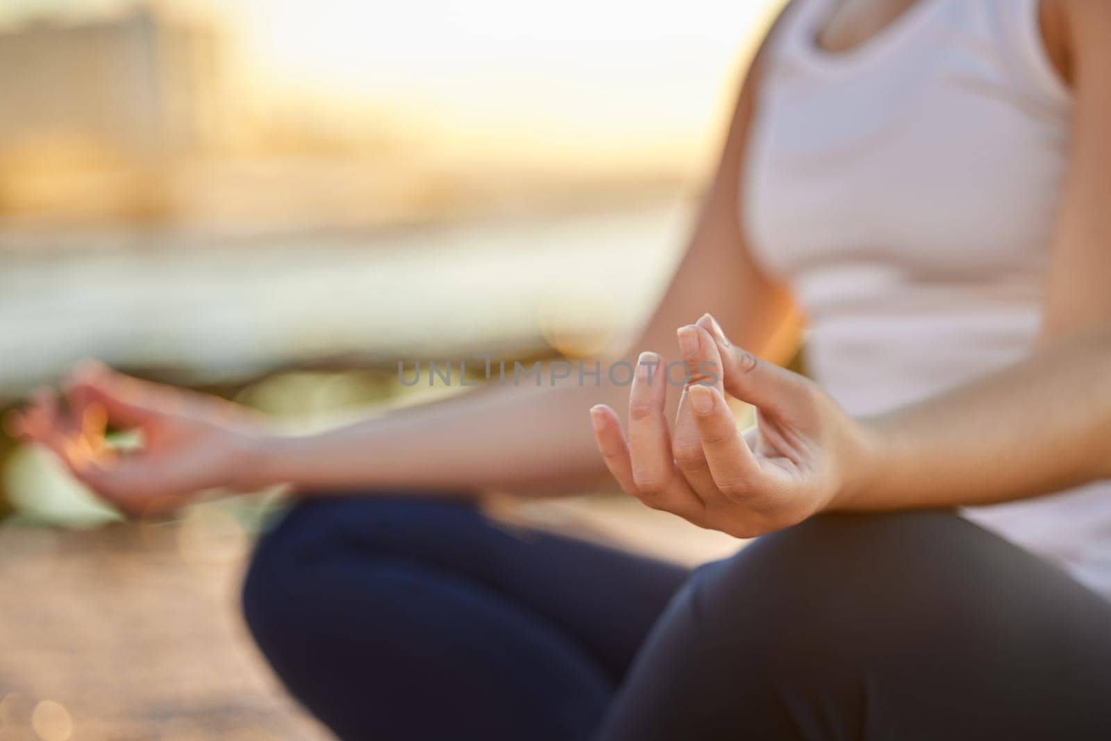 Time to meditate. Cropped shot of an unrecognizable young woman meditating on the beach. by YuriArcurs