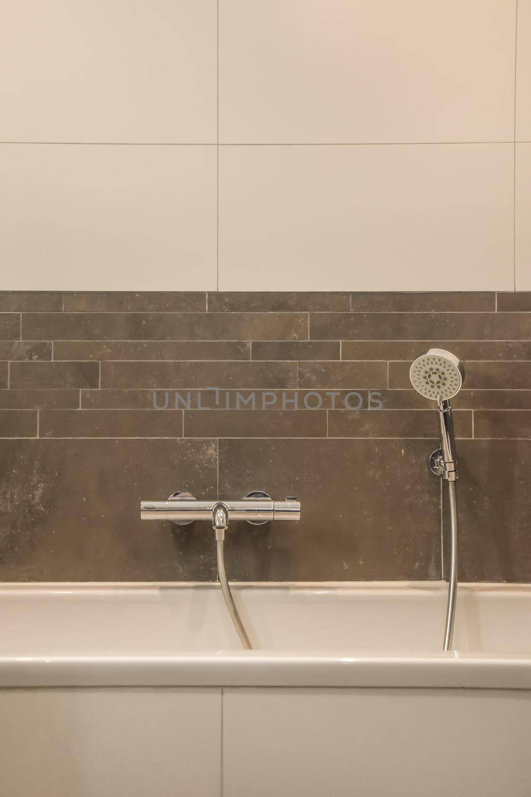 The interior of a bathroom in a modern house decorated with tiles with a bathtub
