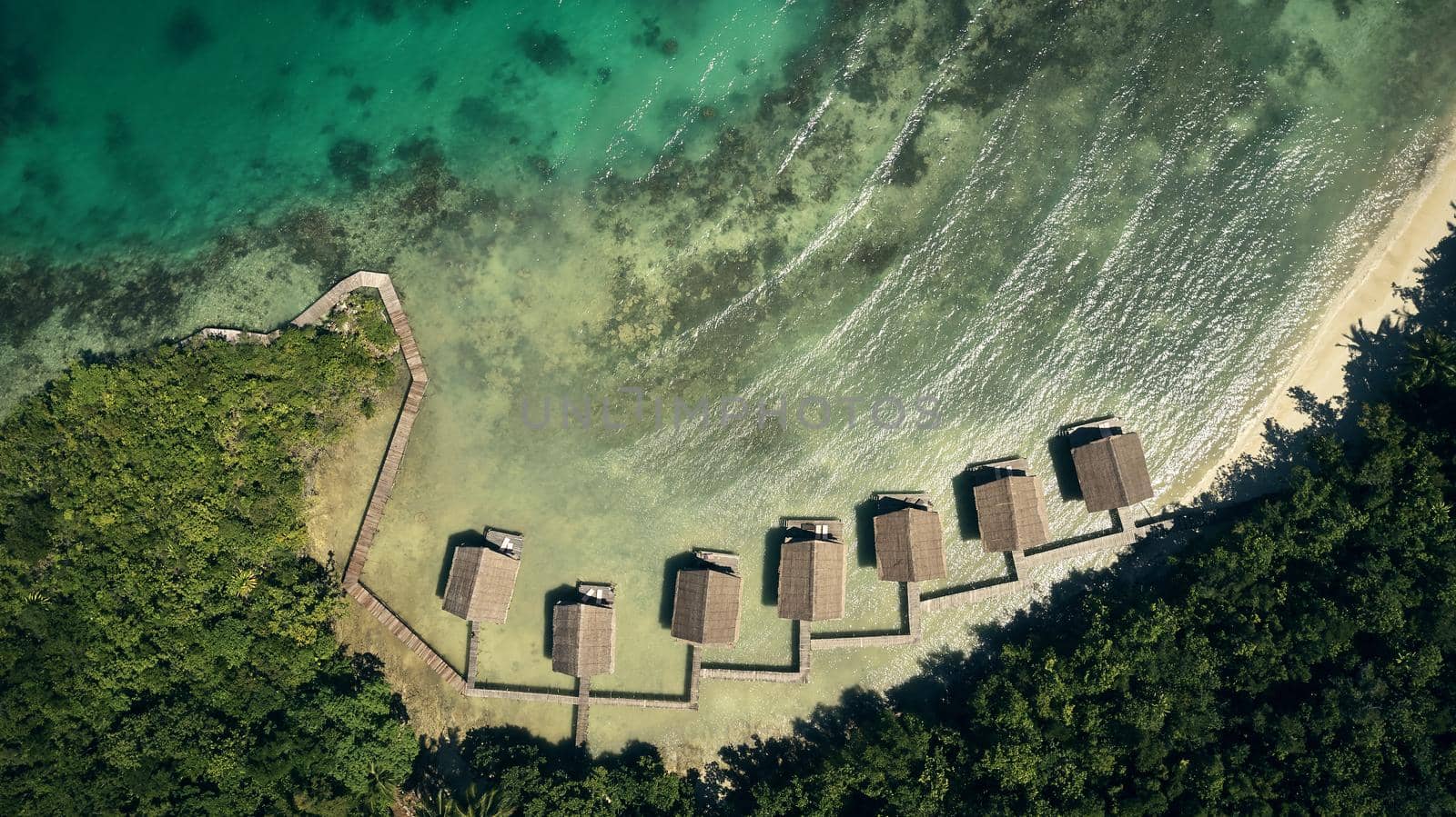 High angle shot of bungalows along the island coasts of Indonesia.