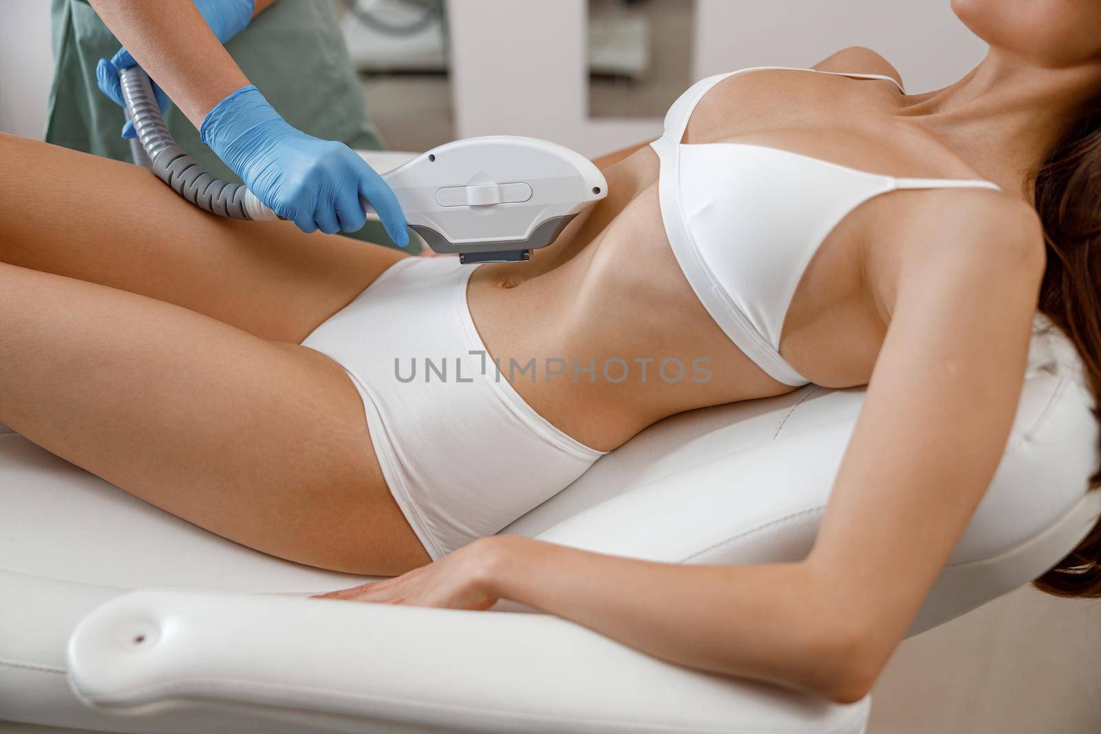 Slim young woman getting photo epilation with ipl machine in beauty salon. Hair removal, cosmetology