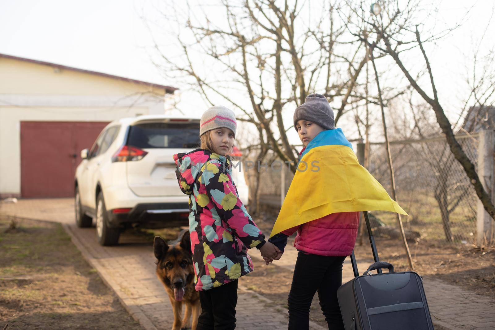 Ukraine military migration. two little girls with a suitcase. Flag of Ukraine, help. Crisis, military conflict.