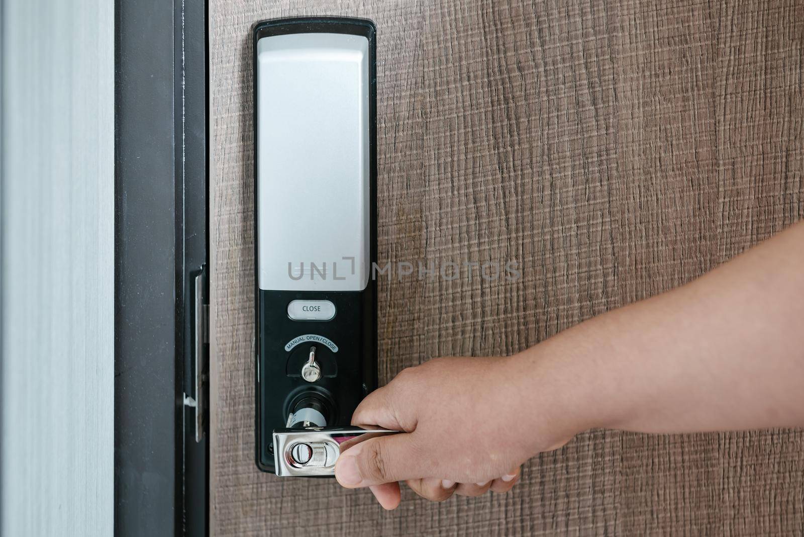Woman Hand is Holding Door Handle While Opening a Door for Access Apartment Building. Electric Door With Keypad Code for Security System in Apartments Room. Electronic Door for Entrance-Exit Building.