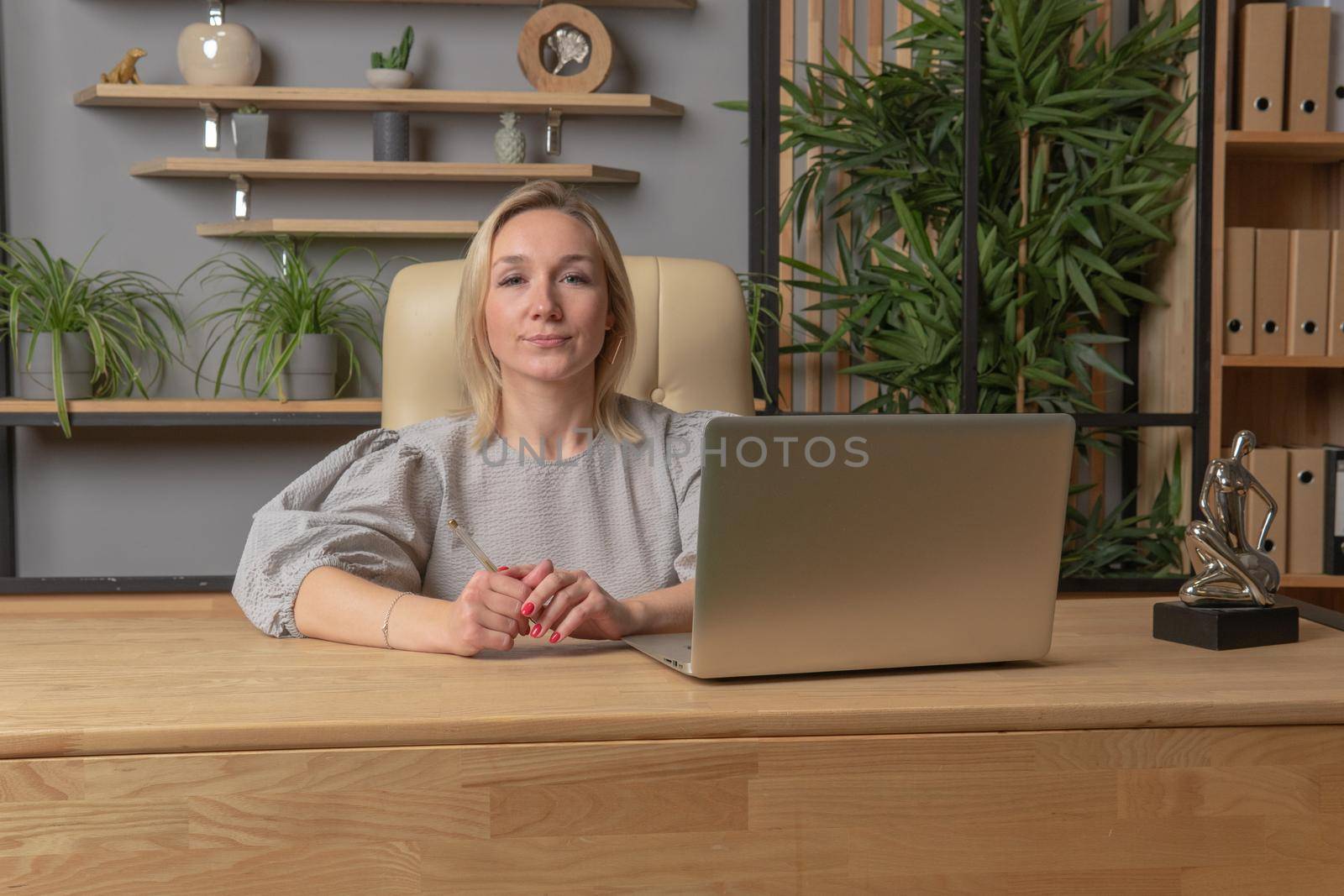 At a table with a laptop sits a girl in the hands of a pen business girl laptop woman work, for person female in online adult typing, student hispanic. Background indoors headphone, evening executive