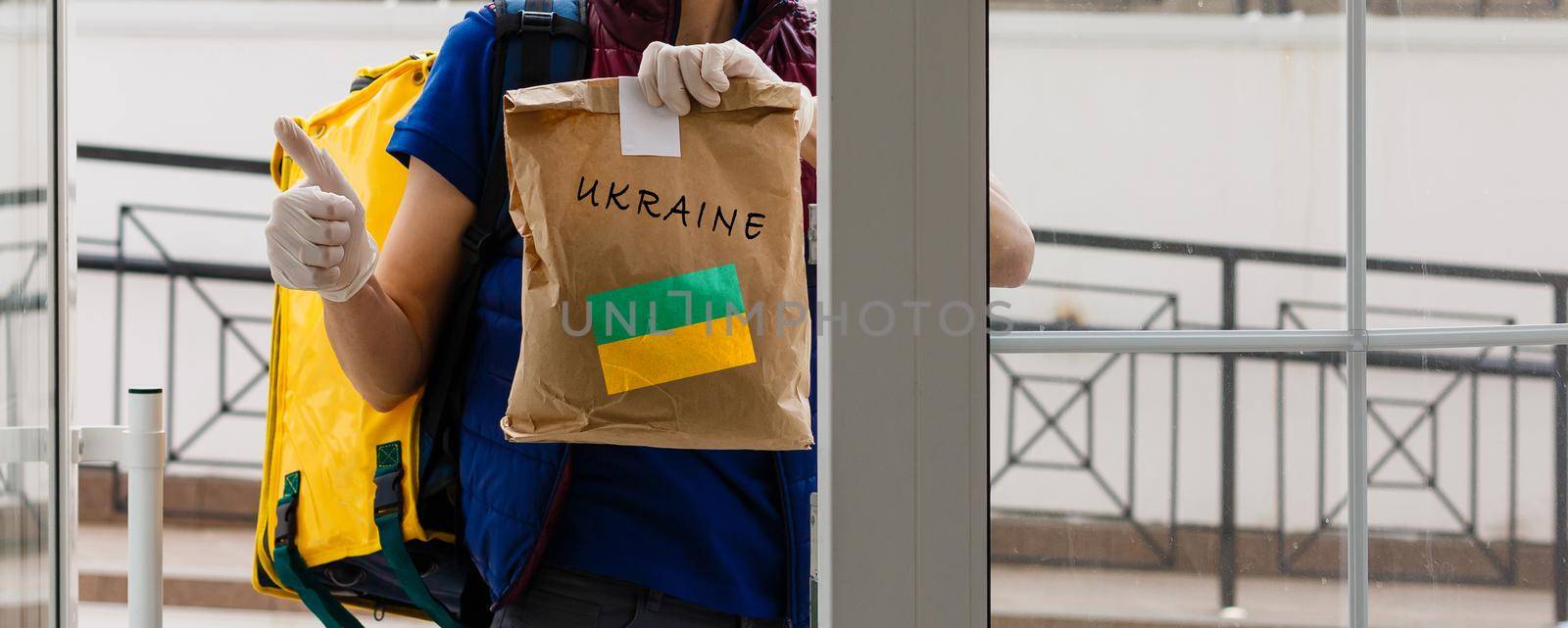 A man holds a box of aid for Ukrainian refugees and poor citizens who find themselves in a war between Ukraine and Russia. Humanitarian aid concept. Donate for refugees