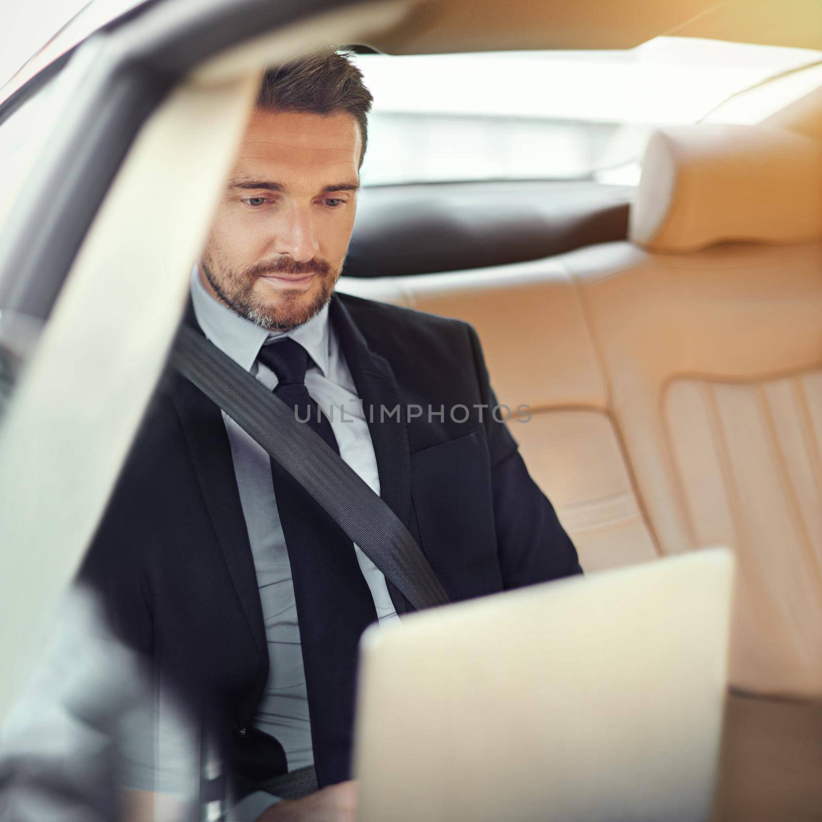 Cropped shot of a businessman in the backseat of a car.