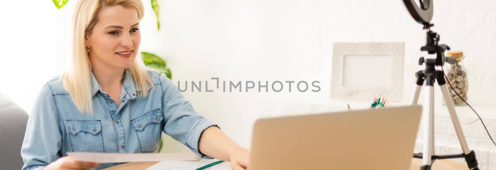 blogger, young woman looking scared while watching something on laptop, recording reaction video blog or vlog.