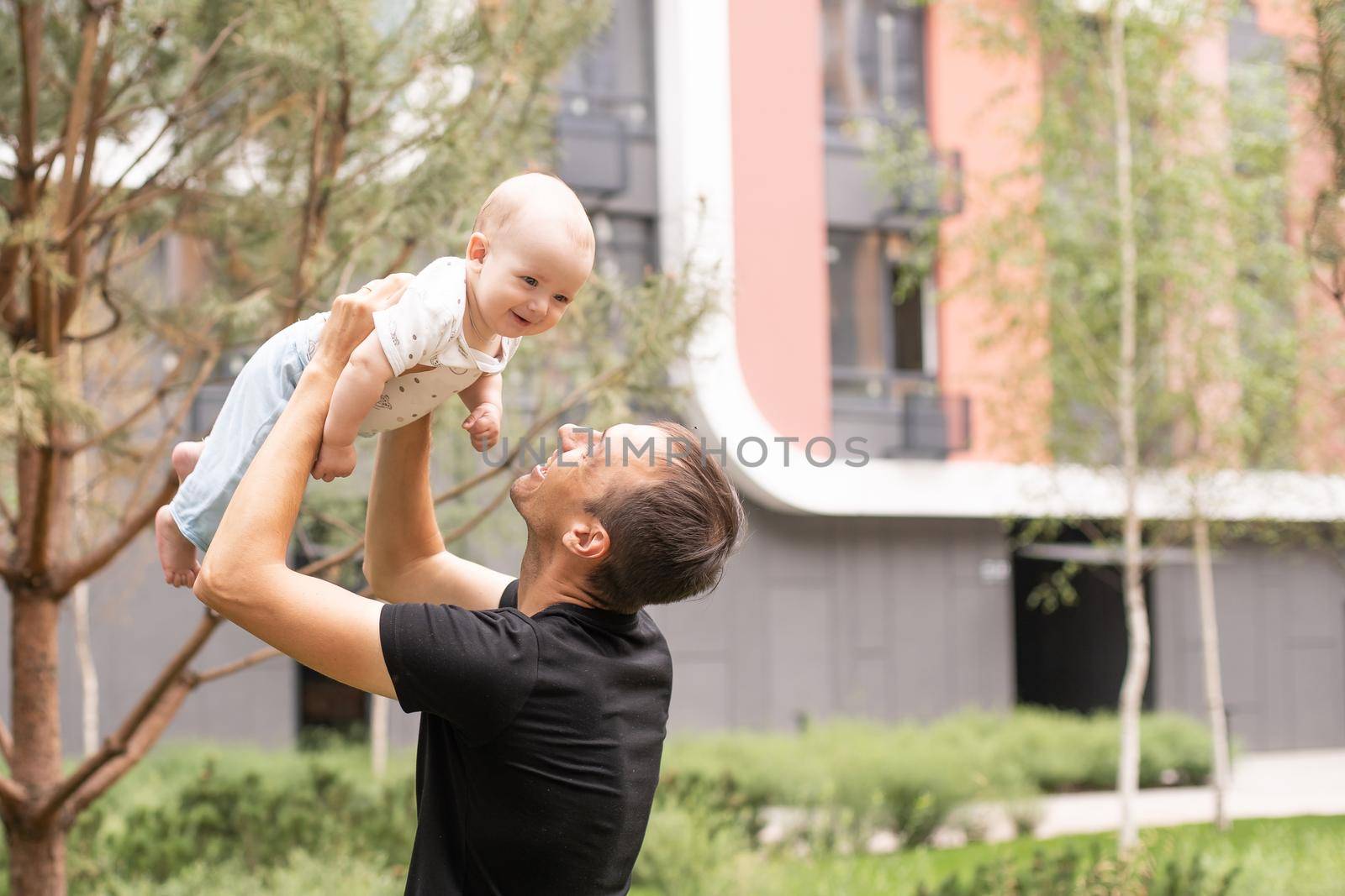 Father and his son walking at summer park.