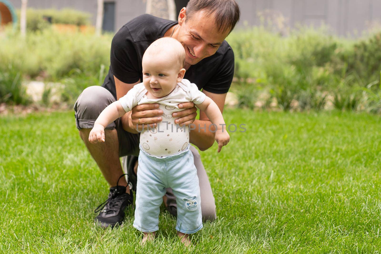 Father and his son walking at summer park.