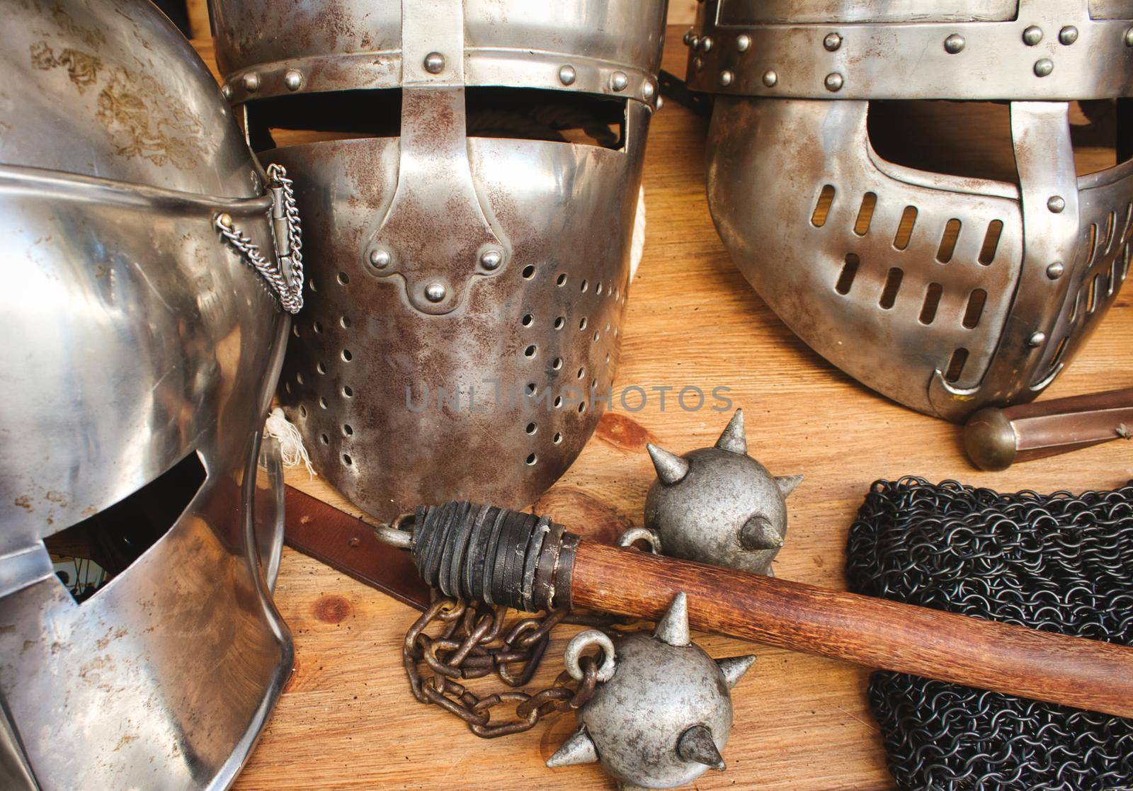 Shiny metal helmets of medieval knights with traditional weapons at a middle age theme festival by tennesseewitney