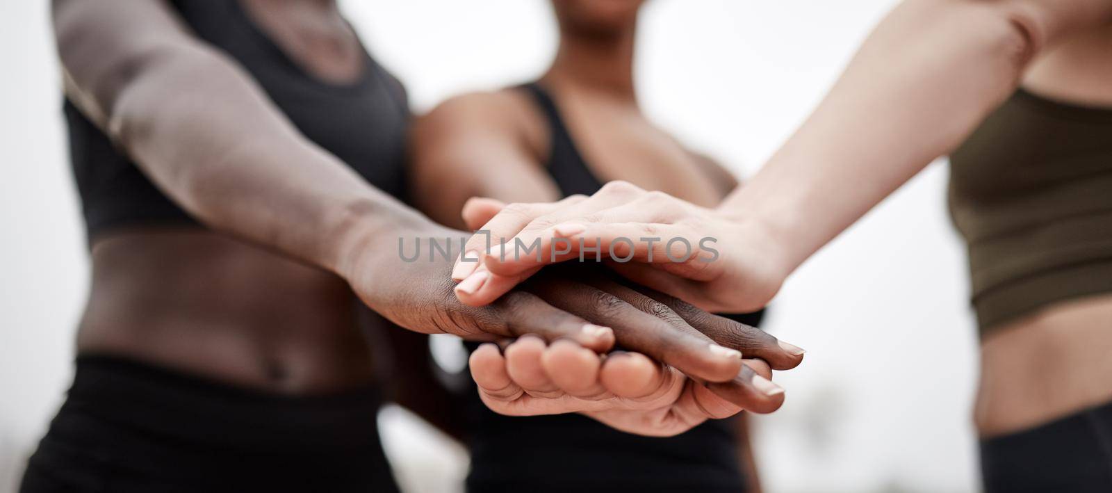 Shot of a team of athletes with their hands stacked.