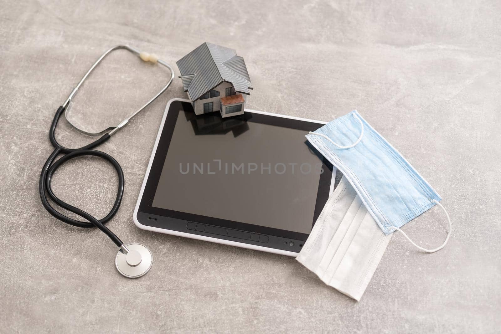 Medical equipment: stethoscope and tablet on grey background.