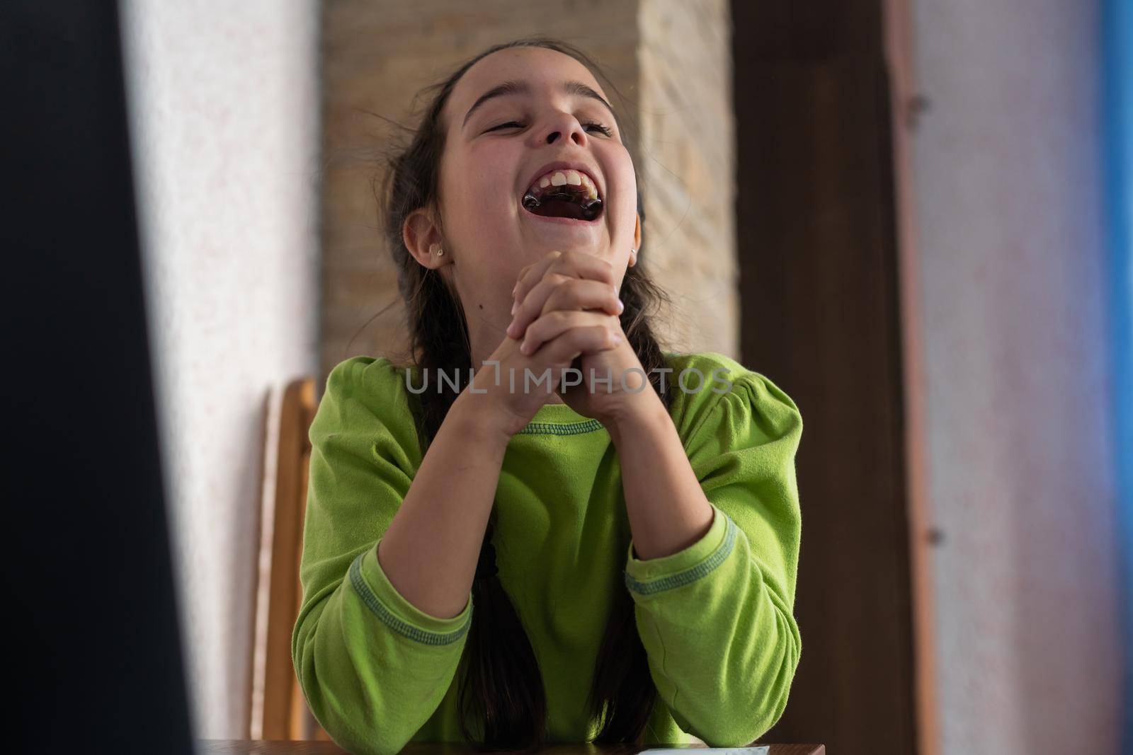 little girl laughs with plates in her mouth