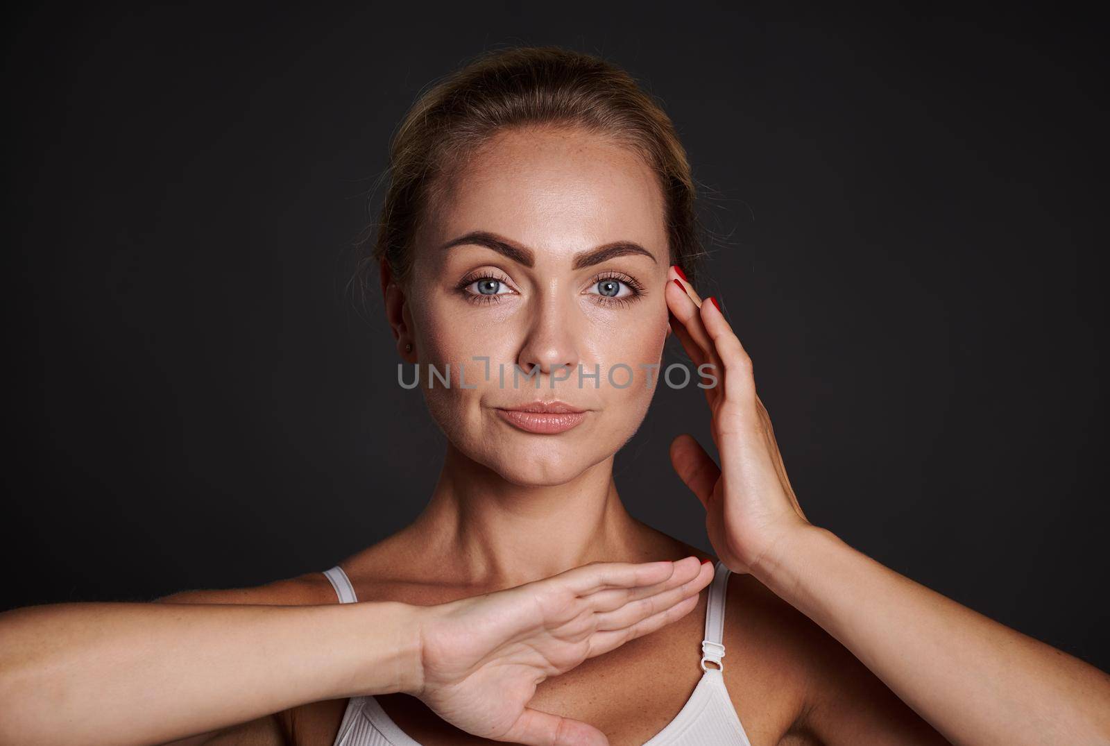 Beautiful middle aged Caucasian woman with healthy fresh glowing skin. Close-up. Cosmetology, skin care, anti-aging and beauty treatment concept