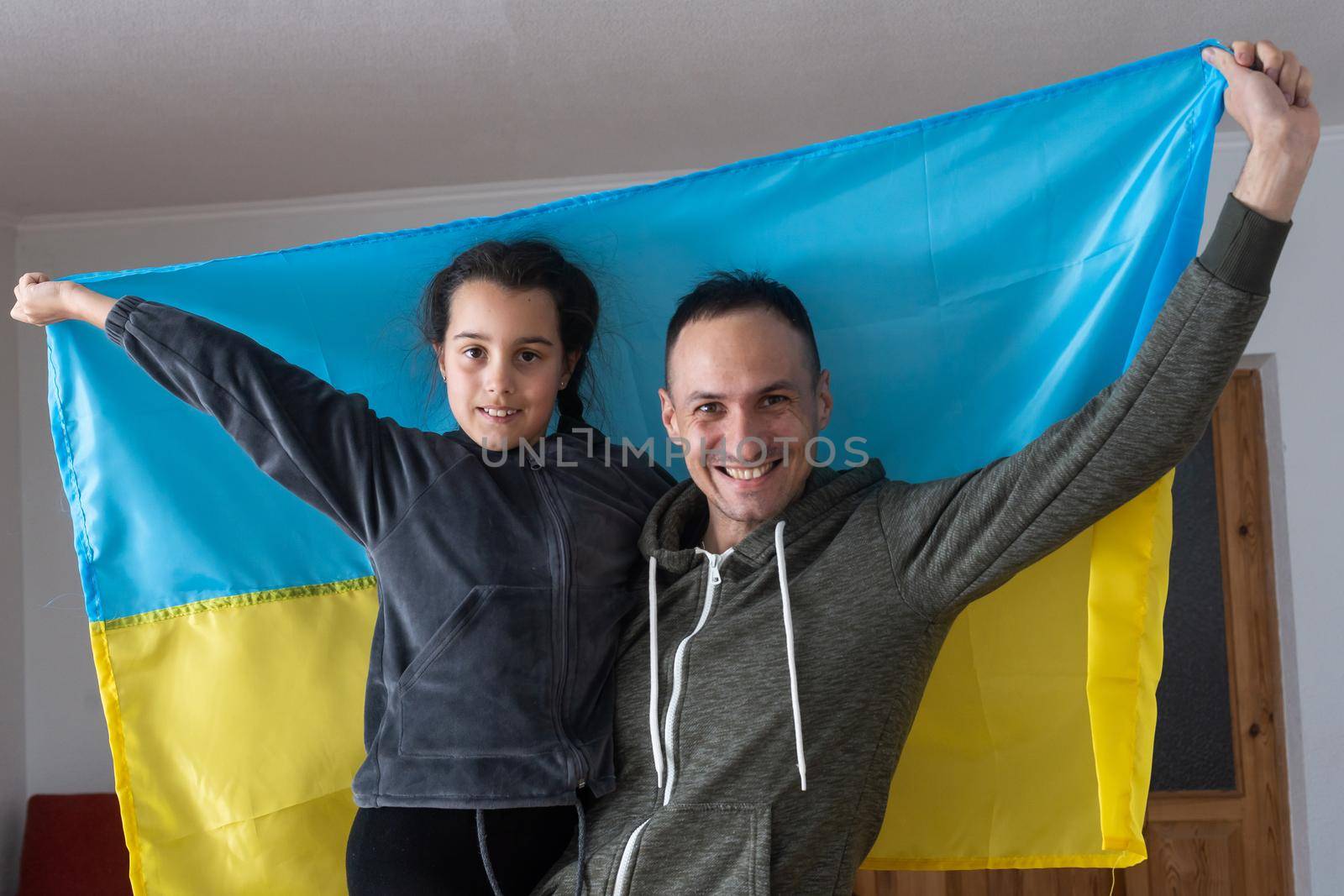 Father with daughter holding Ukrainian flag. Peace and pray for Ukraine.