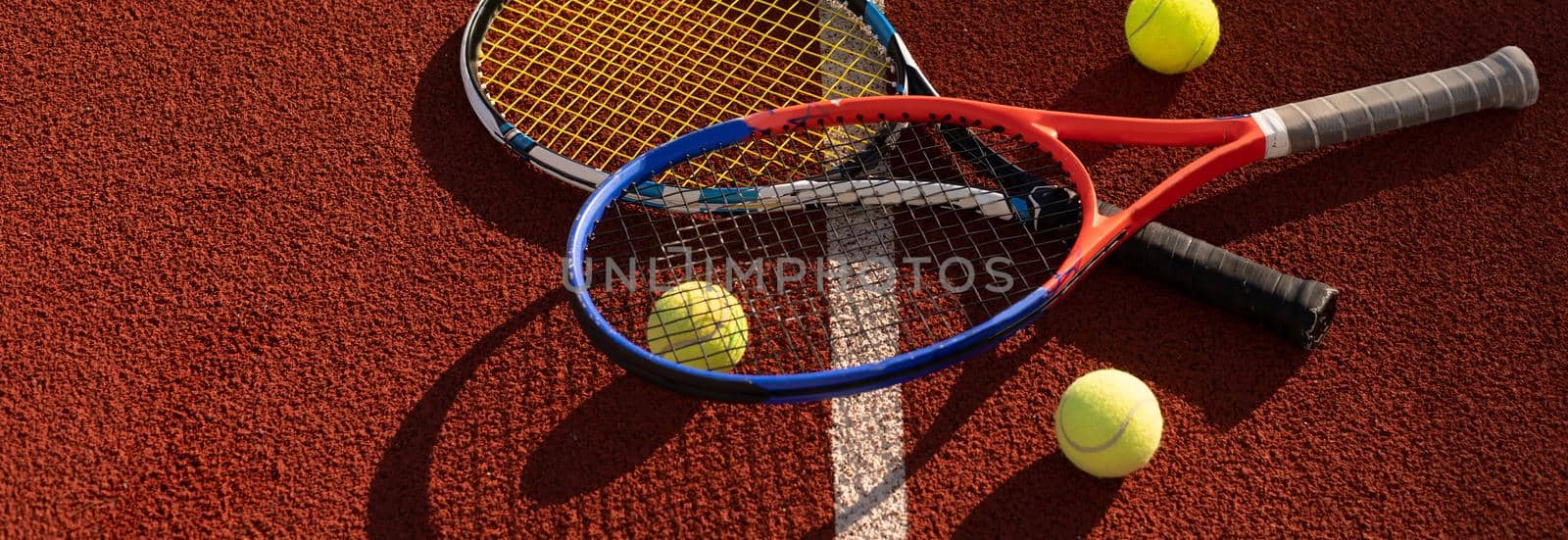 Close up view of two tennis rackets and balls on the tennis court