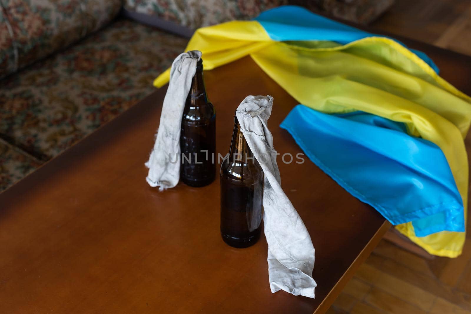 Molotov cocktail bottle on flag of ukraine background.