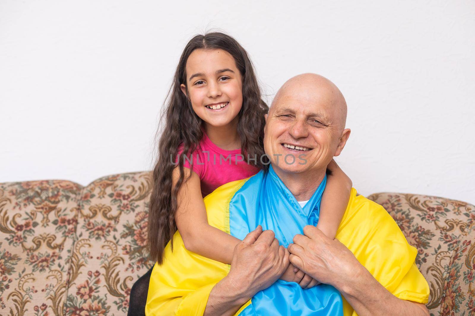 elderly man and girl with the flag of Ukraine.