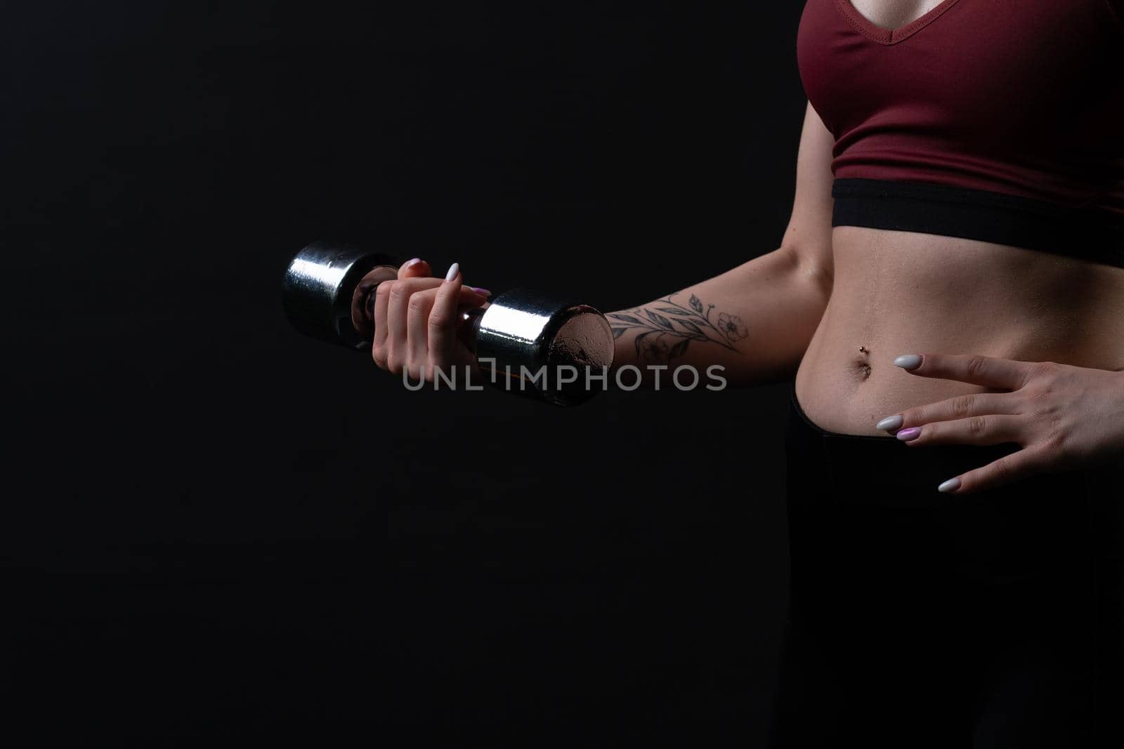 Her kira a dumbbells in knightly shiny holds as beautiful hands girl dumbbells sports body, from health fit from person from trainer athlete, beautiful biceps. Sweat model bodybuilder