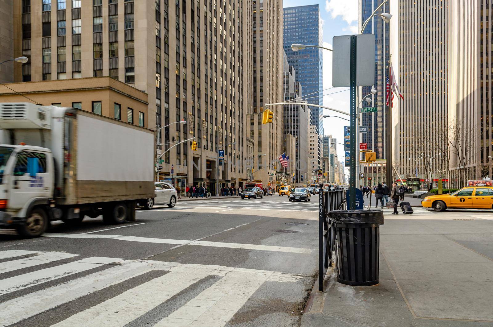 Manhattan New York City, Street near Radio City Music Hall with lots of traffic, crosswalk and trash bin in the forefront, horizontal