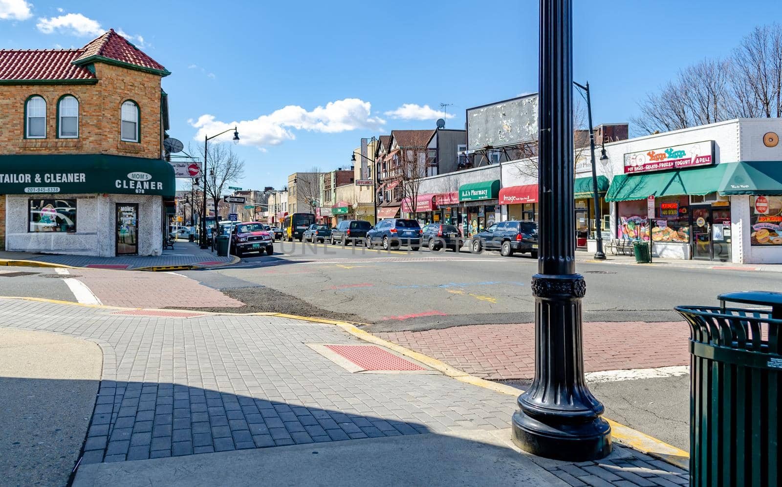 Different grocery and Retail Stores at Center of the City near Cliffside Park, New Jersey, during a sunny winter day, view from the other side of the street, cars parked in front of the stores, horizontal