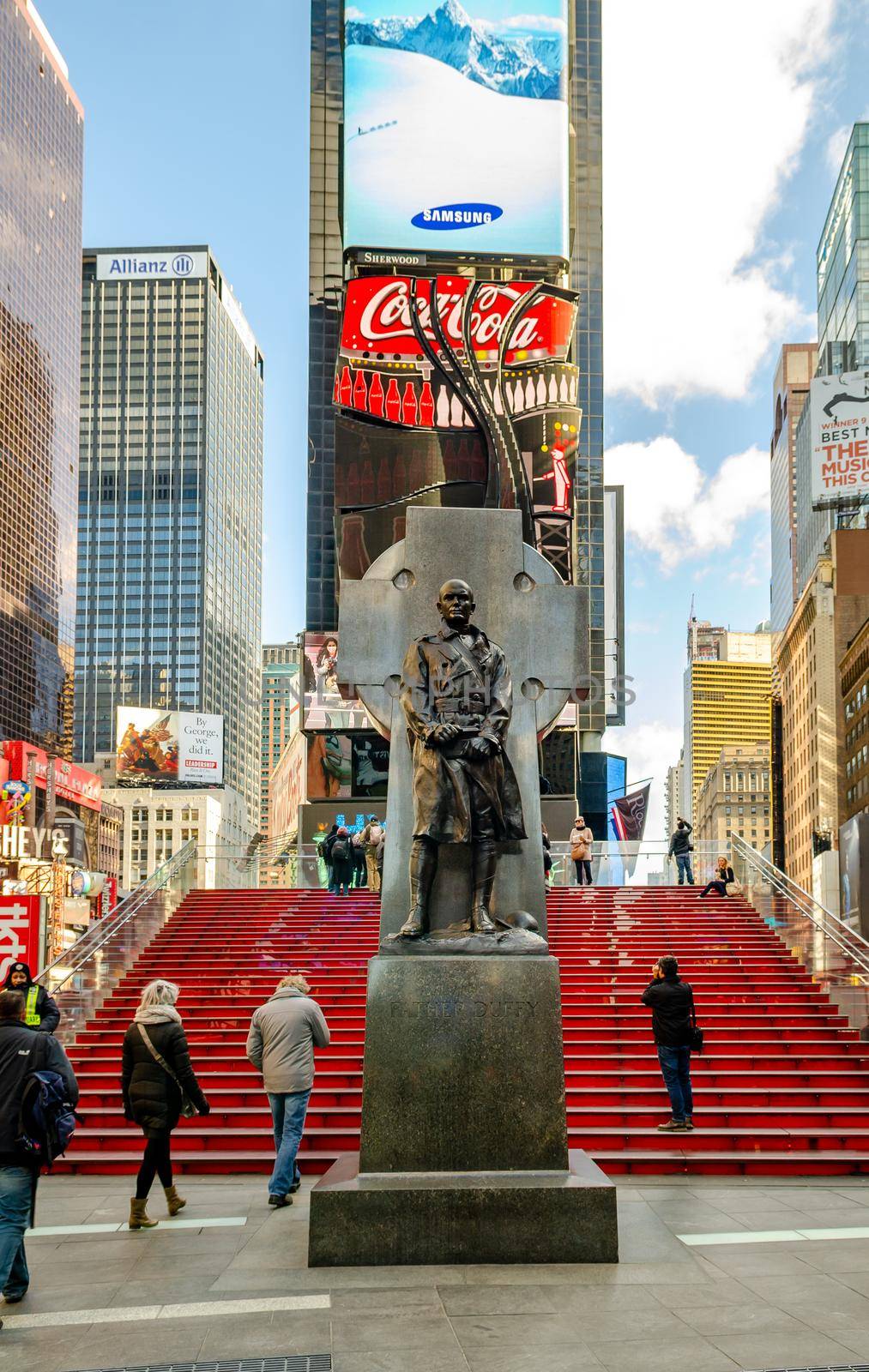 Duffy Square Monument with red Staircase at Time Square New York, People walking on the stairs, low angle view during daytime, vertical