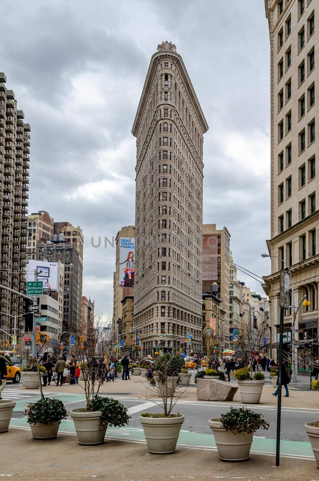 Flatiron Building New York City with People and Plants in forefront by bildgigant