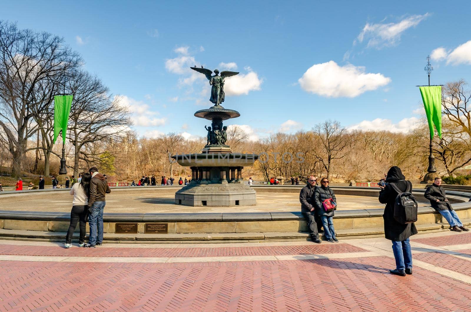 Bethesda Fountain with Angel of the Waters Sculpture, front view, Central Park New York during winter, people standing and walking around the fountain, clear sky, horizontal