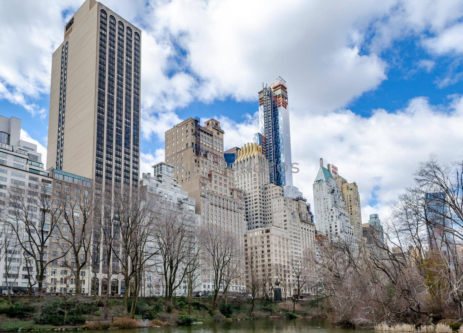 Skyline of Manhattan with Essex House Skyscraper, The Pond at Central Park Lake in forefront by bildgigant