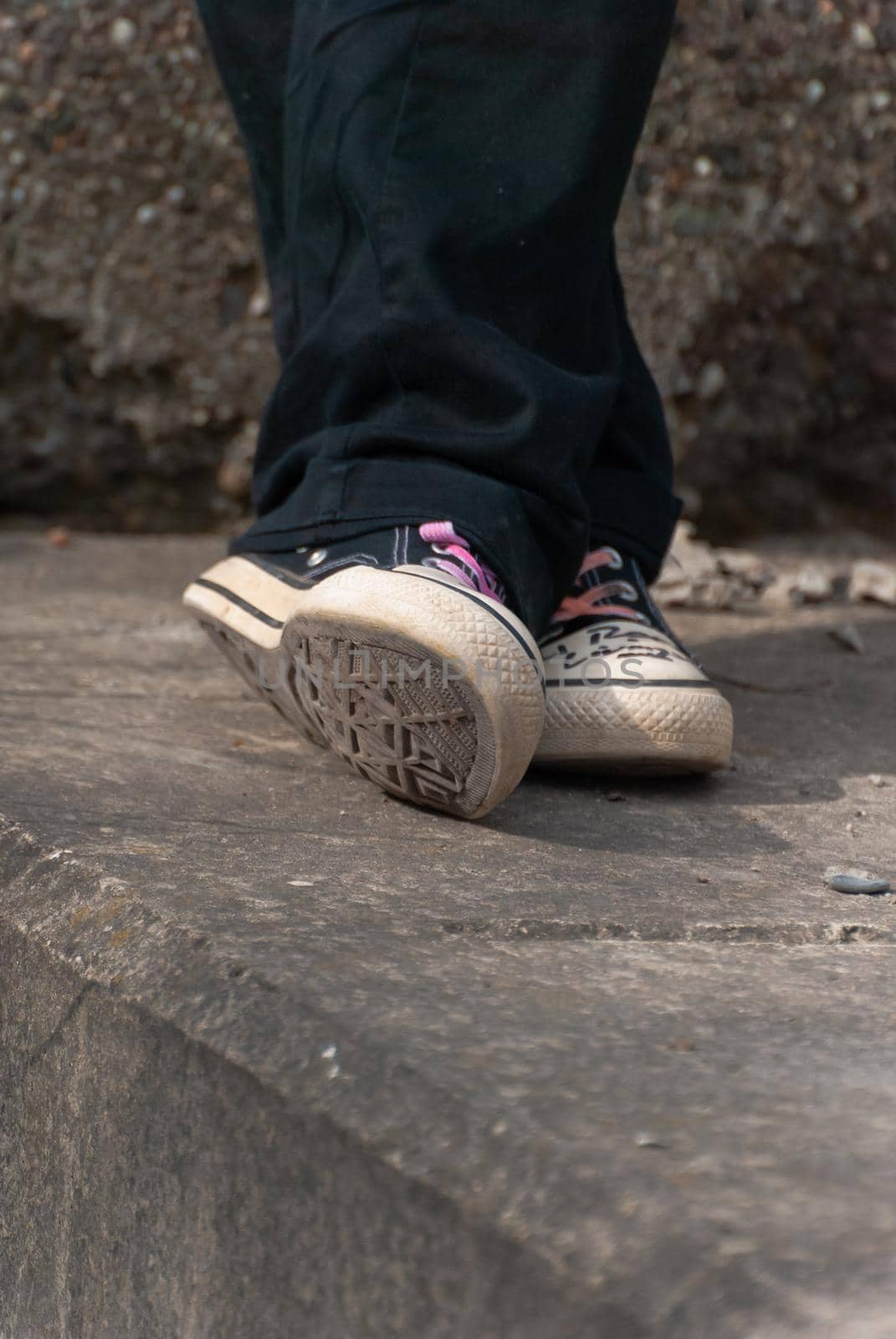 Alternative Punk emo girl standing on a conrete wall, close-up, vertical