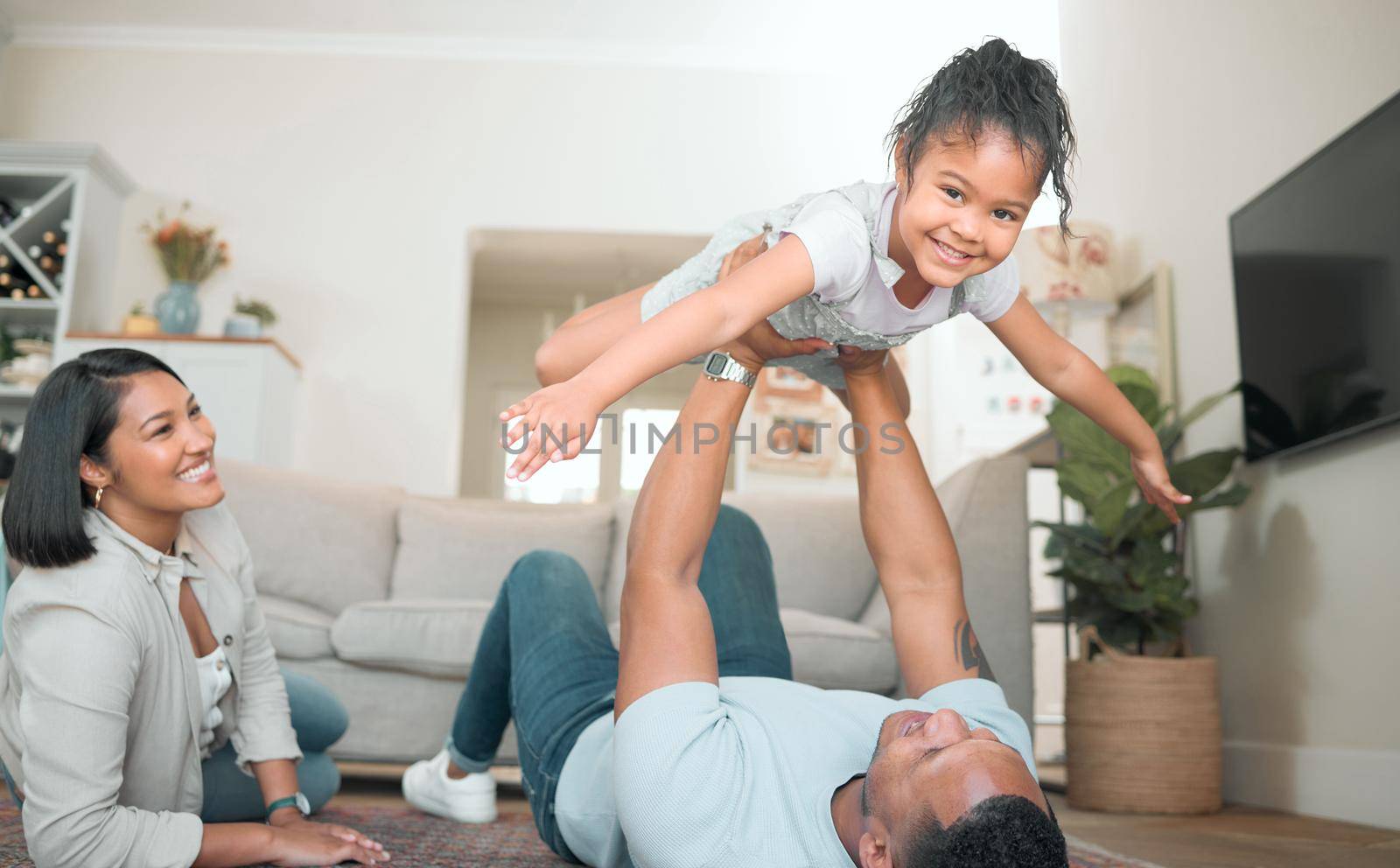 Shot of an adorable little girl bonding with her parents in the living room at home.