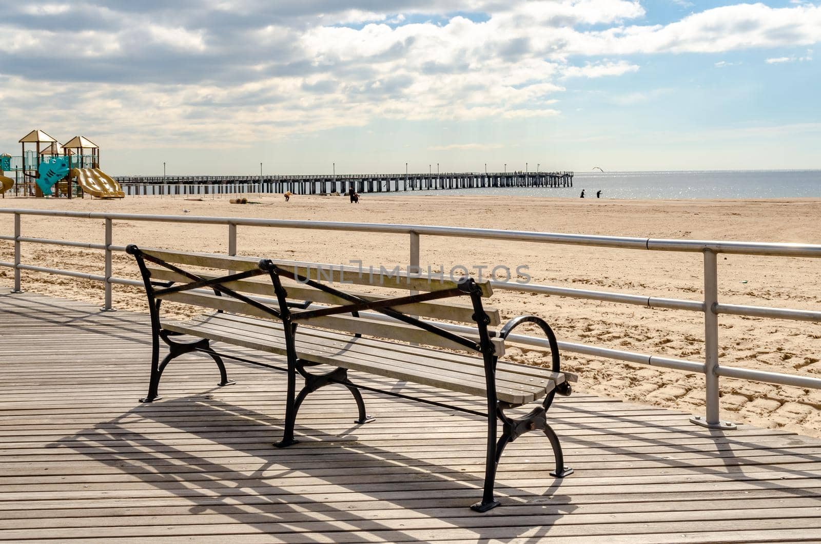 Bench at Beach Promenade of Coney Island with Pat Auletta Steeplechase Pier in Background, NYC by bildgigant