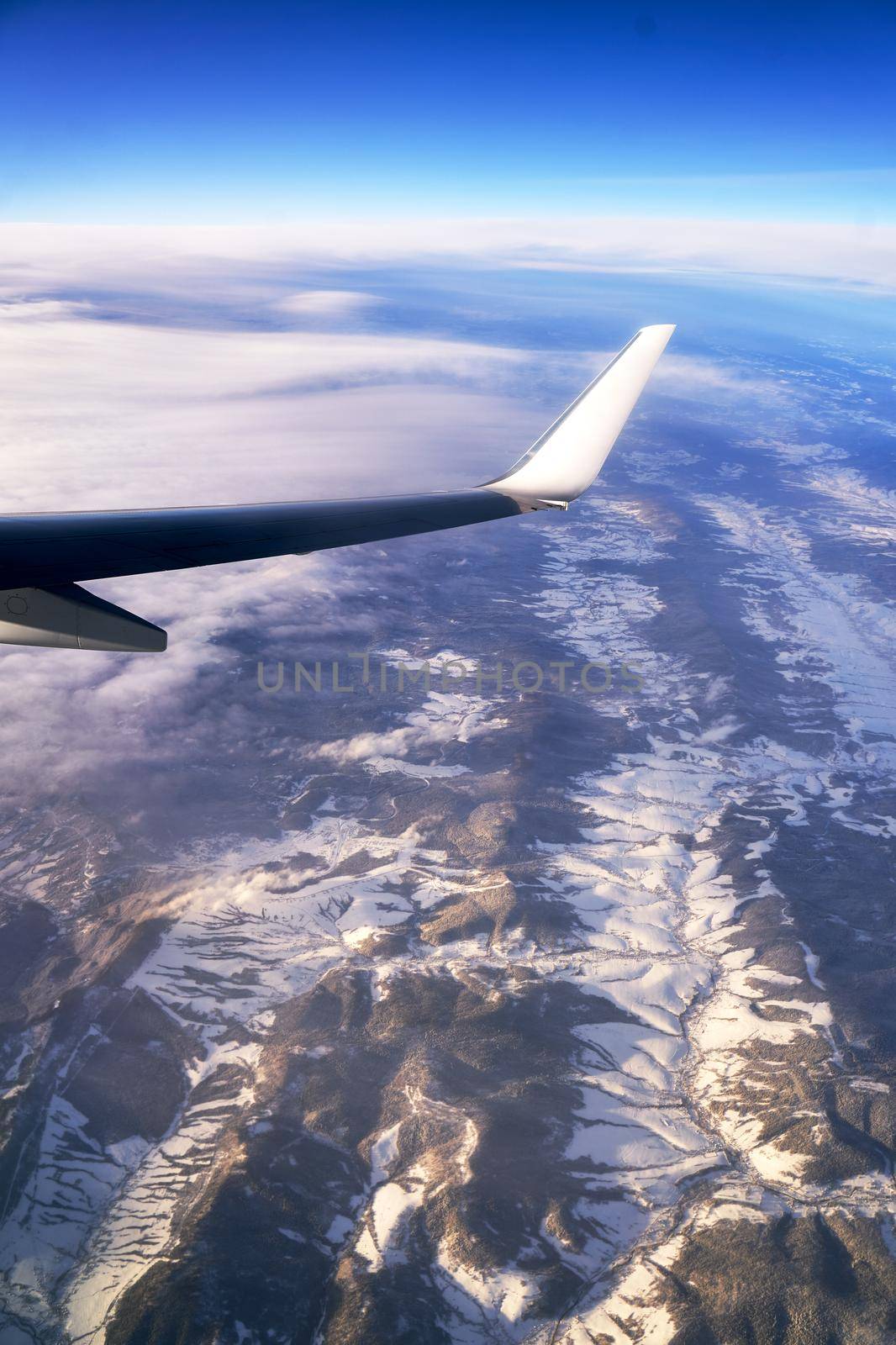 Flying and traveling. View from airplane window on the wing during sunset.