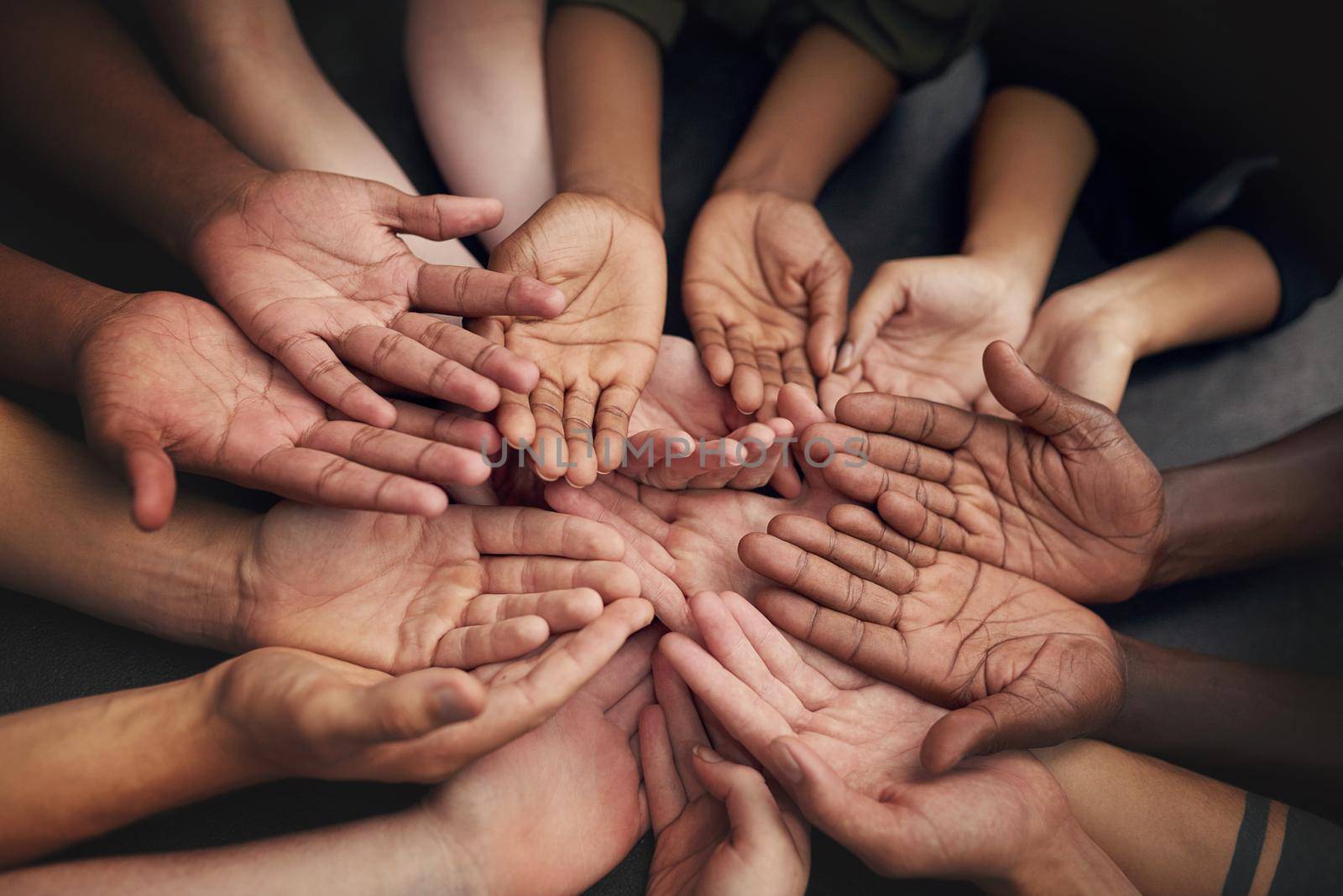 High angle shot of a group of unrecognizable peoples hands out with their palms open.